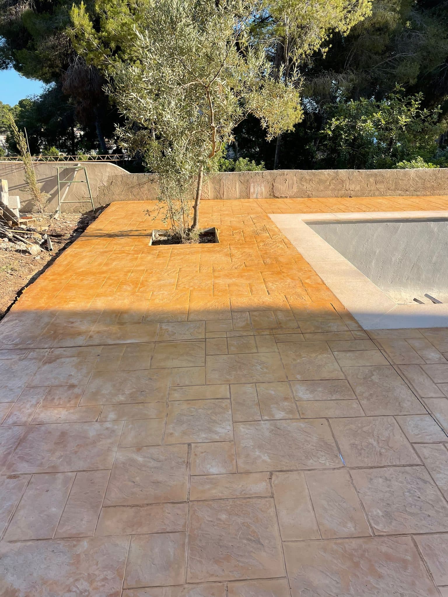 Chalé con jardín y piscina pavimentado en hormigón impreso manteado en gris y marrón
