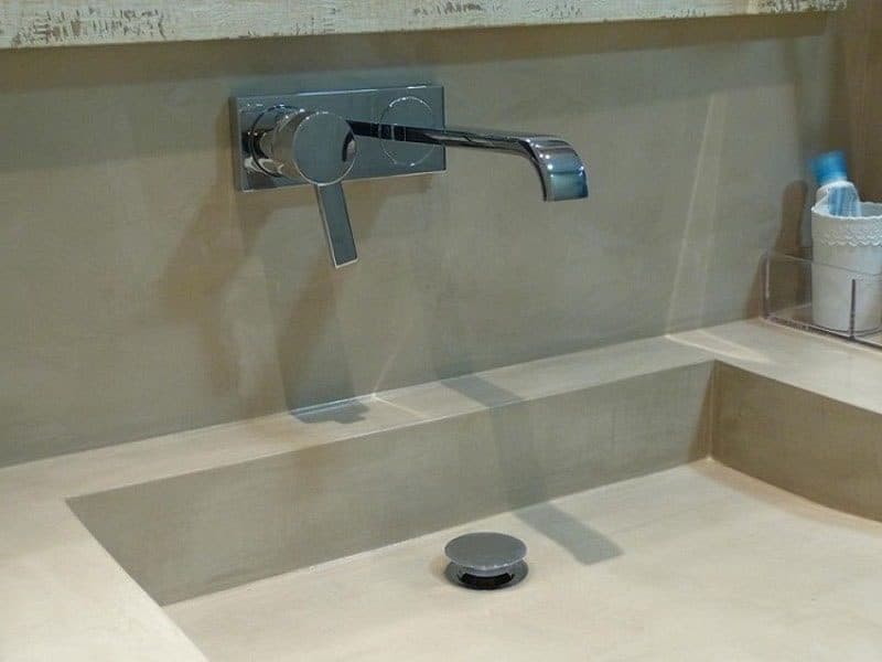 Bañera y paramentos del cuarto de baño revestidos en microcemento gris claro
